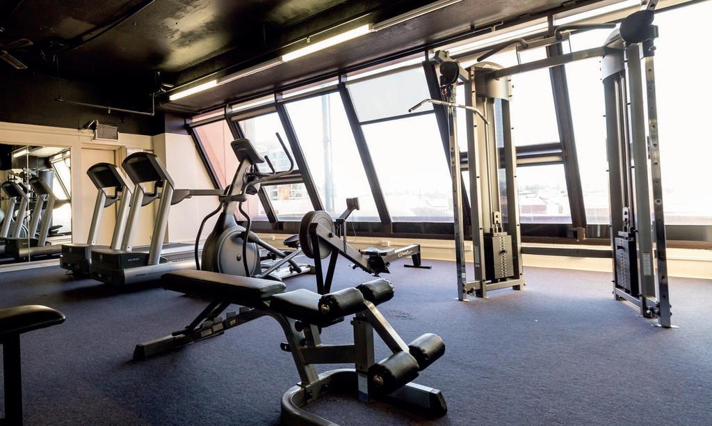 Hotel Stamford Grand Adelaide à Glenelg Extérieur photo The photo shows a modern gym interior with several exercise machines. There are cardio machines, likely including treadmills and possibly an elliptical machine, along one side. In the center, there is a weight bench and a rowing machine. Additionally
